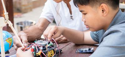 Grandfather and grandson work together on an electronics project
