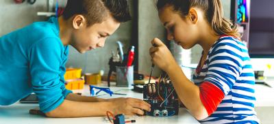 male and female middle schoolers engaged in STEM at home